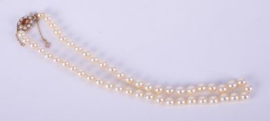 A string of cultured pearls with a creamy pale lemon colour lustre, approx. 7.5mm, strung to a 9ct