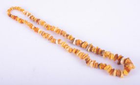 A string of mixed amber beads in varying colours and organic shapes, 71.22gm, length 26"