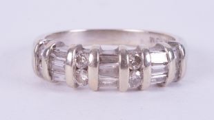 A 14k white gold ring set with a mixture of round brilliant cut & baguette cut diamonds, 3.77gm,