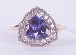 A 9ct yellow gold ring set with a triangular cut Tanzanite, AAA quality, 1.29 carats, surrounded