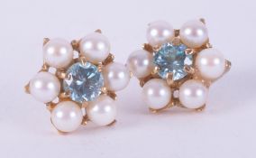 A pair of 9ct yellow gold flower cluster style earrings set with a central blue zircon surrounded by