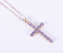 A 9ct yellow gold cross set with round cut tanzanite, length of pendant approx. 4cm, on a 19" 9ct