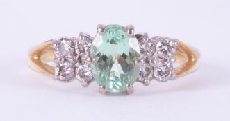 An 18ct yellow & white gold bespoke hand made ring set with a central oval cut Paraiba