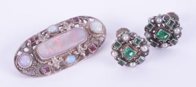 A silver (no hallmarks) ornate oval shaped brooch set with white cabochon cut opals and square cut