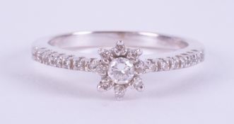 An 18ct white gold flower design ring set with round brilliant cut diamonds, the central
