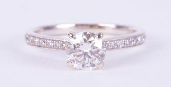 An 18ct white gold ring set with a central round brilliant cut diamond, approx. 0.65 carats,