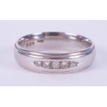 A platinum band set with five small round brilliant cut diamonds, 5mm width, 6.48gm, size M 1/2. 9