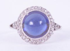 A platinum cluster style ring (no hallmarks & not tested) set with a central cabochon cut blue stone