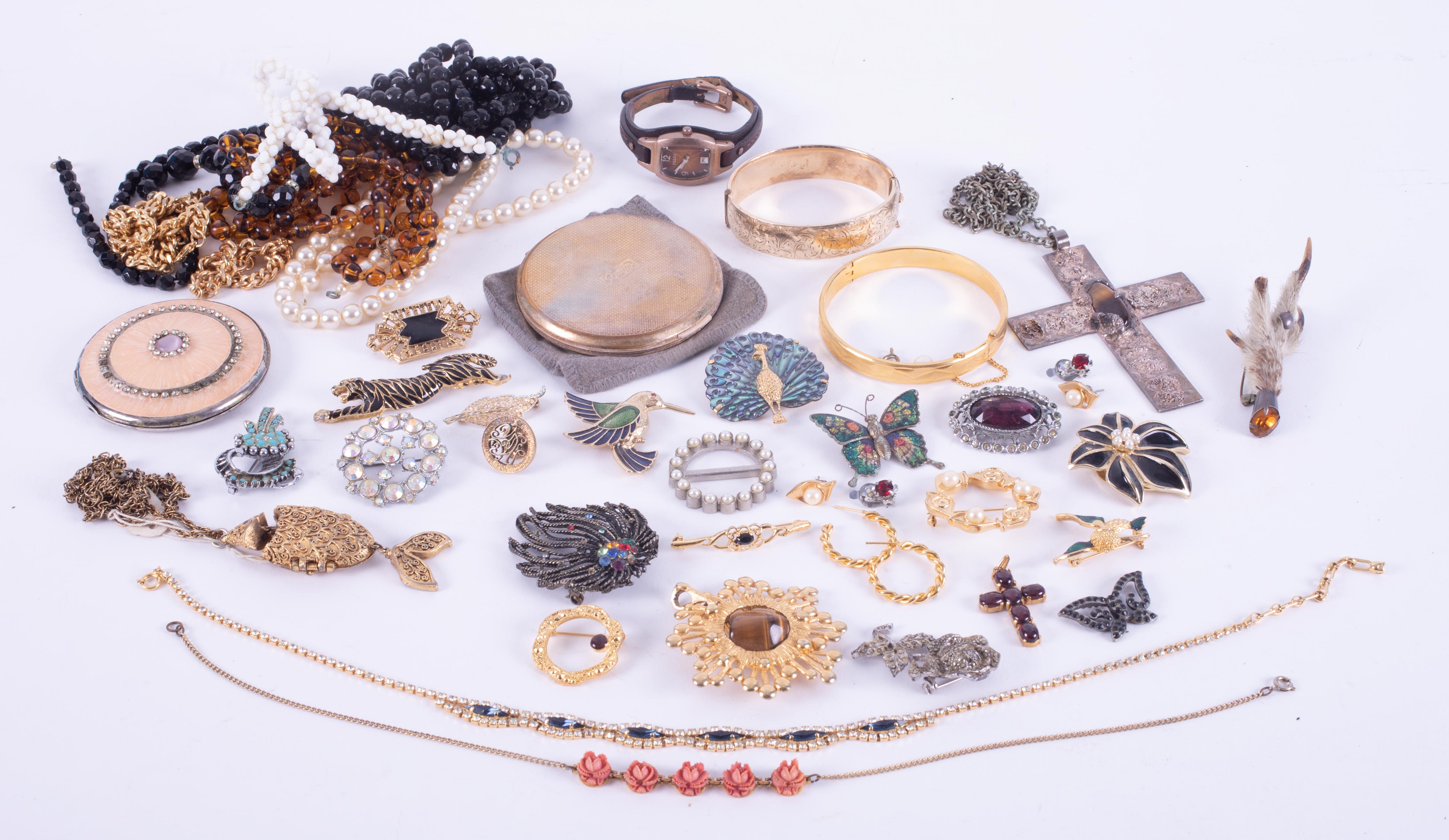 A bag of mixed costume jewellery to include bangles, beads, compacts, brooches, necklaces, Fossil