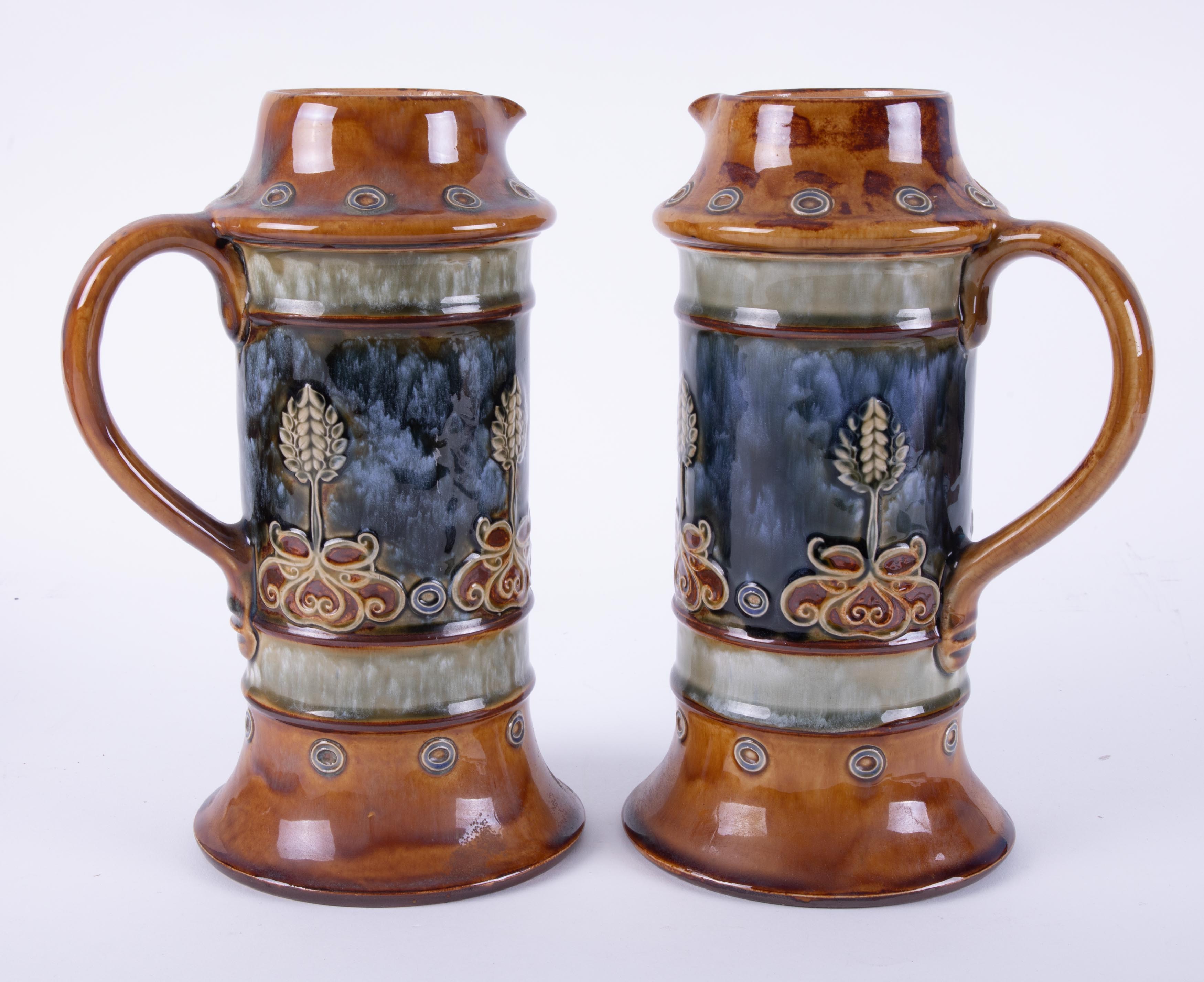 A pair of Royal Doulton art pottery handled jugs, impress marks, height 28cm.
