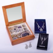 A selection of costume jewellery in a wooden jewellery box to include rings, earrings, necklaces,