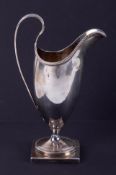 A George III silver helmet shaped cream jug on square base, circa 1788, possibly Charles Haugham,