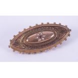 A 9ct yellow gold ornate mourning brooch with a flower design comprising of little seed pearls and a