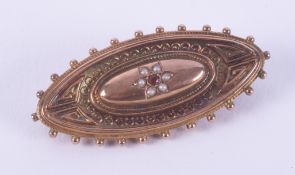 A 9ct yellow gold ornate mourning brooch with a flower design comprising of little seed pearls and a