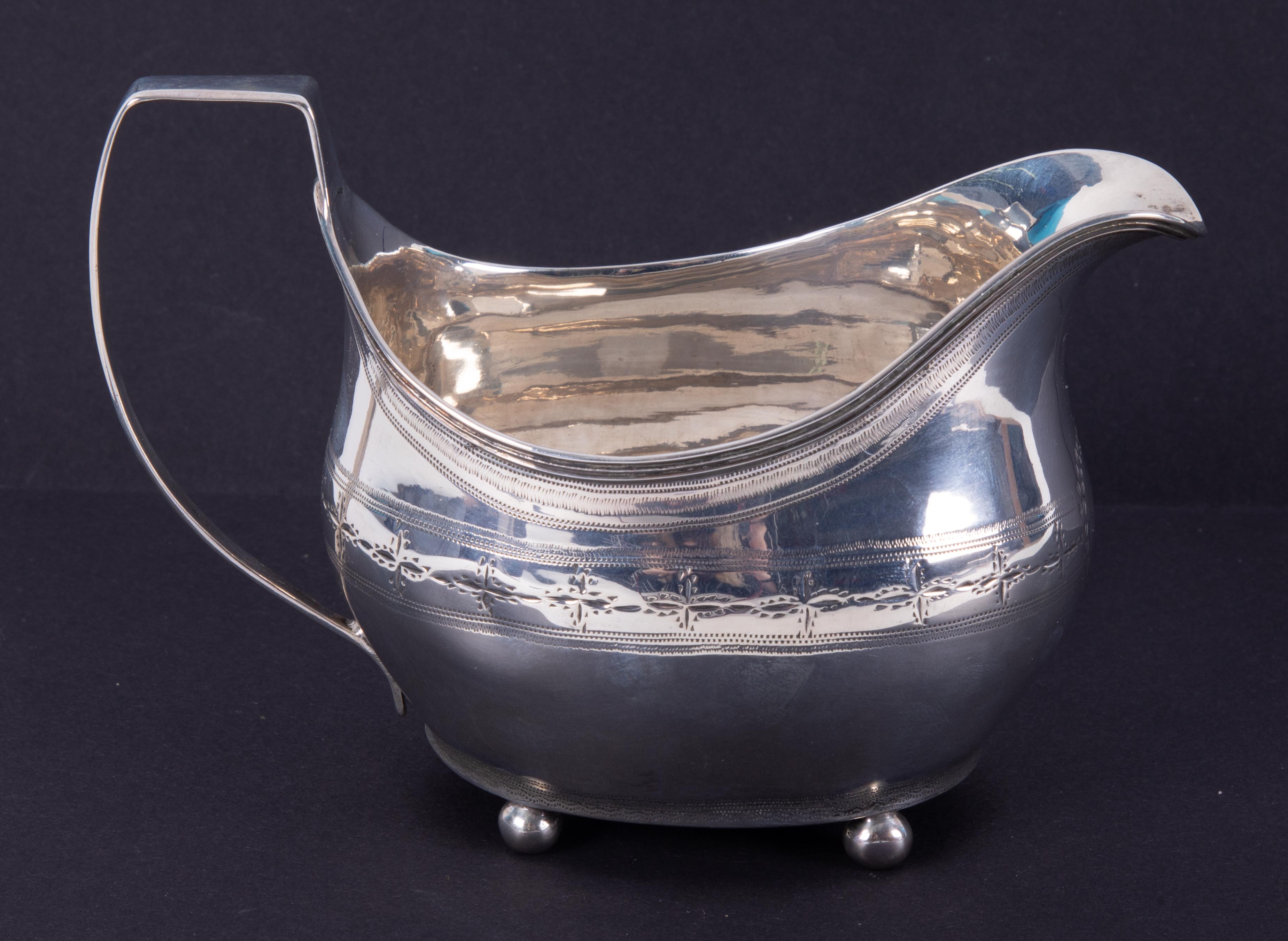 A Georgian silver cream jug with engraved decoration, approx. 3.97oz.