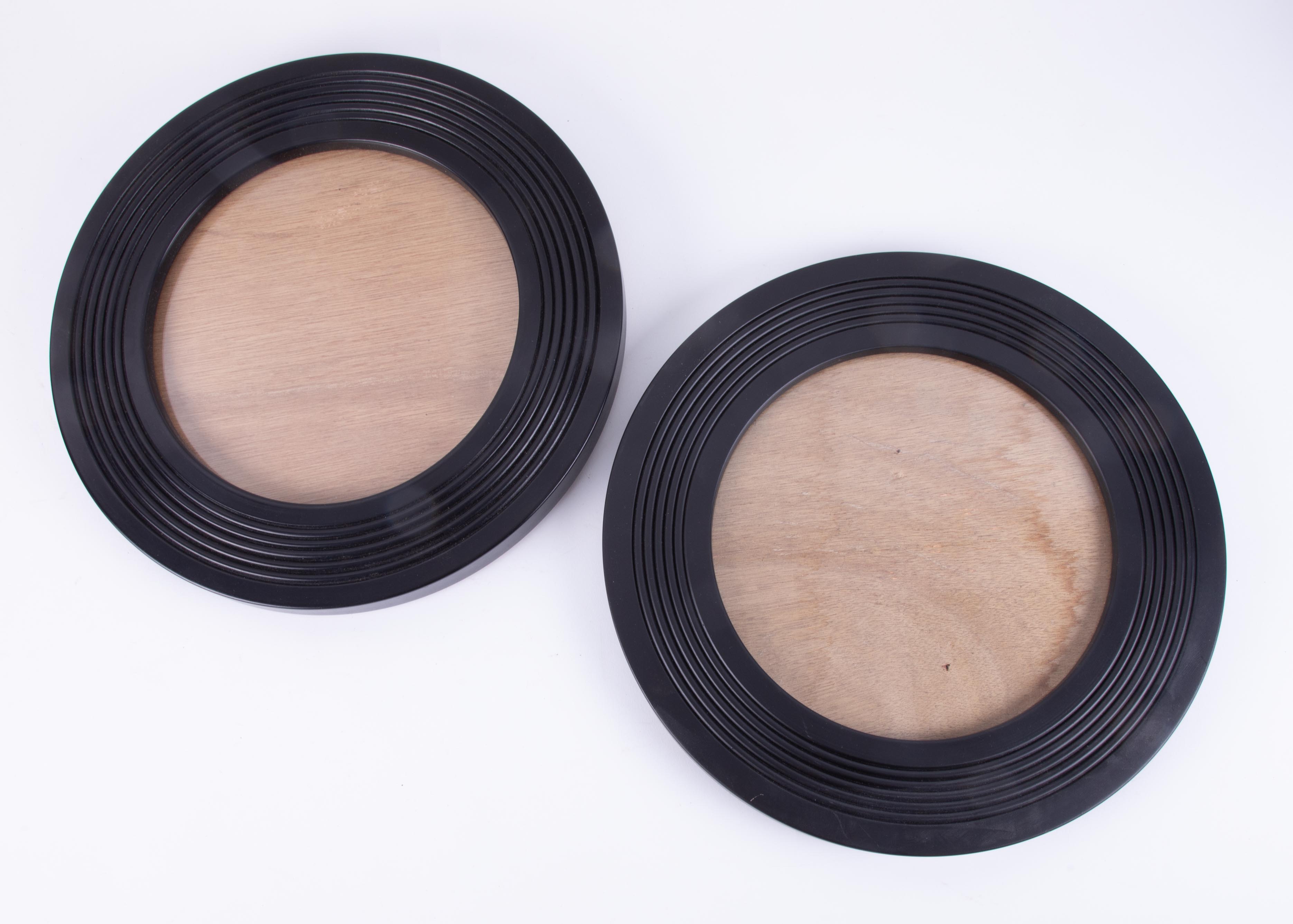 A pair of black circular picture frames, diameter 23cm.