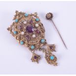 An ornate costume jewellery brooch/pendant set with faux stones and a 15ct yellow gold stick pin,