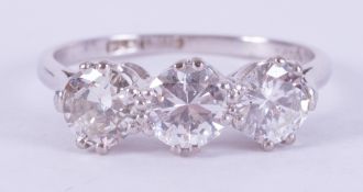 A platinum three stone ring set with three round brilliant cut diamonds, total weight approx. 1.78