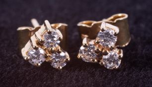 A pair of 18ct yellow gold trefoil design stud earrings set with round brilliant cut diamonds, total