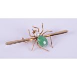 A 14ct spide brooch set with an oval cabochon cut jade measuring approx. 10mm x 7.5mm and a round