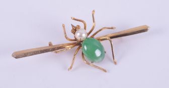 A 14ct spide brooch set with an oval cabochon cut jade measuring approx. 10mm x 7.5mm and a round