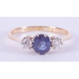 An 18ct yellow gold & platinum three stone ring set with a central slightly oval cut sapphire,