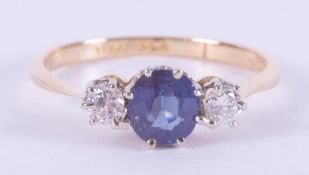 An 18ct yellow gold & platinum three stone ring set with a central slightly oval cut sapphire,