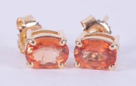 A pair of 18ct yellow gold stud earrings set with oval cut orange sapphires, total weight approx.