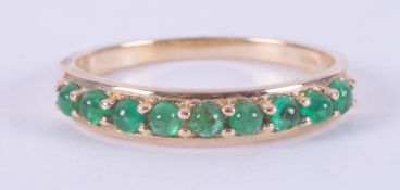 A 9ct yellow gold ring set with nine cabochon cut Colombian emeralds, total weight 0.48 carats, 1.