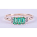 A 9ct yellow gold ring set with three baguette cut Colombian emeralds, total weight 0.55 carats with