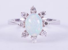 An 18ct white gold cluster ring set with a central oval cabochon cut white opal measuring approx.