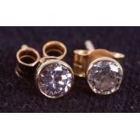 A pair of 18ct yellow gold solitaire studs set with round brilliant cut diamonds, total weight