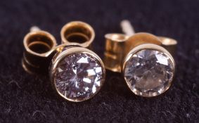 A pair of 18ct yellow gold solitaire studs set with round brilliant cut diamonds, total weight