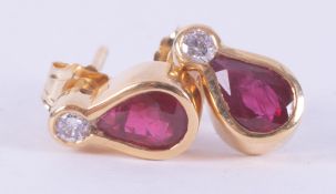 A pair of 18ct yellow gold stud earrings set with pear shaped rubies, total weight approx. 0.52