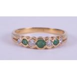 An 18ct yellow gold half eternity style ring set with three round cut emeralds, total weight approx.