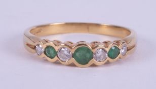 An 18ct yellow gold half eternity style ring set with three round cut emeralds, total weight approx.