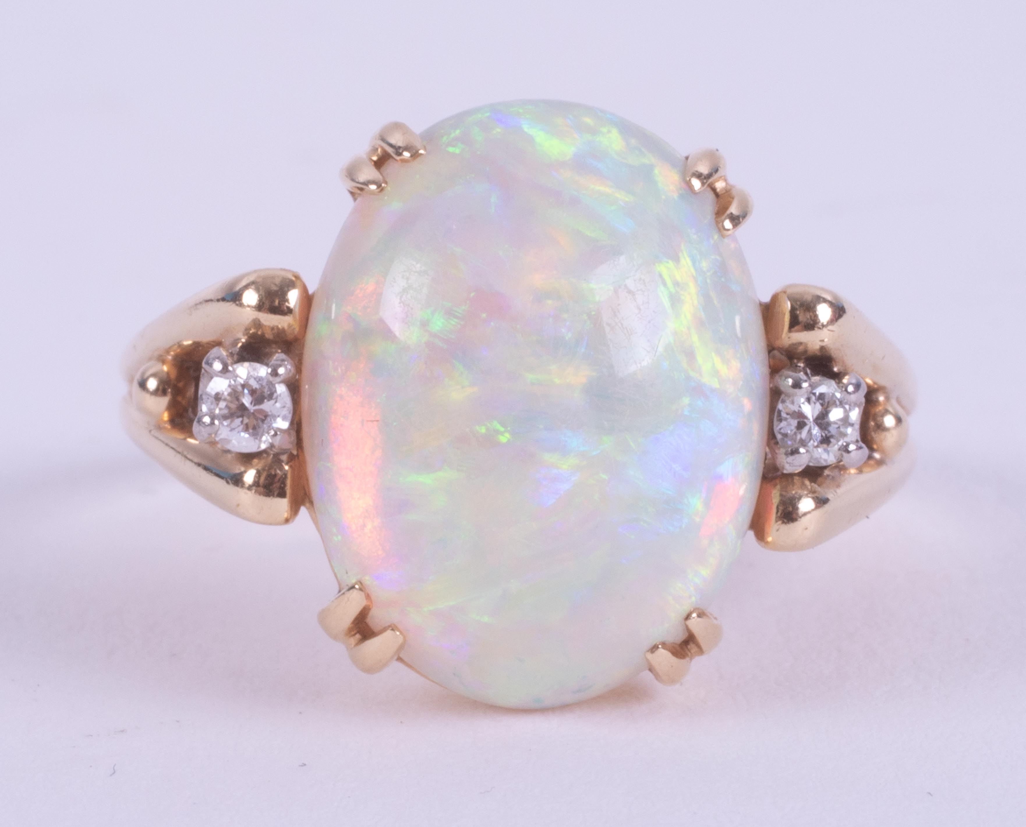 A 14ct yellow gold ring set with a central oval cabochon cut white opal, measuring approx. 15.9mm