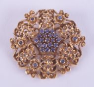 An 18ct yellow gold flower design brooch set with round cut sapphires, diameter 3.5cm, with pin &