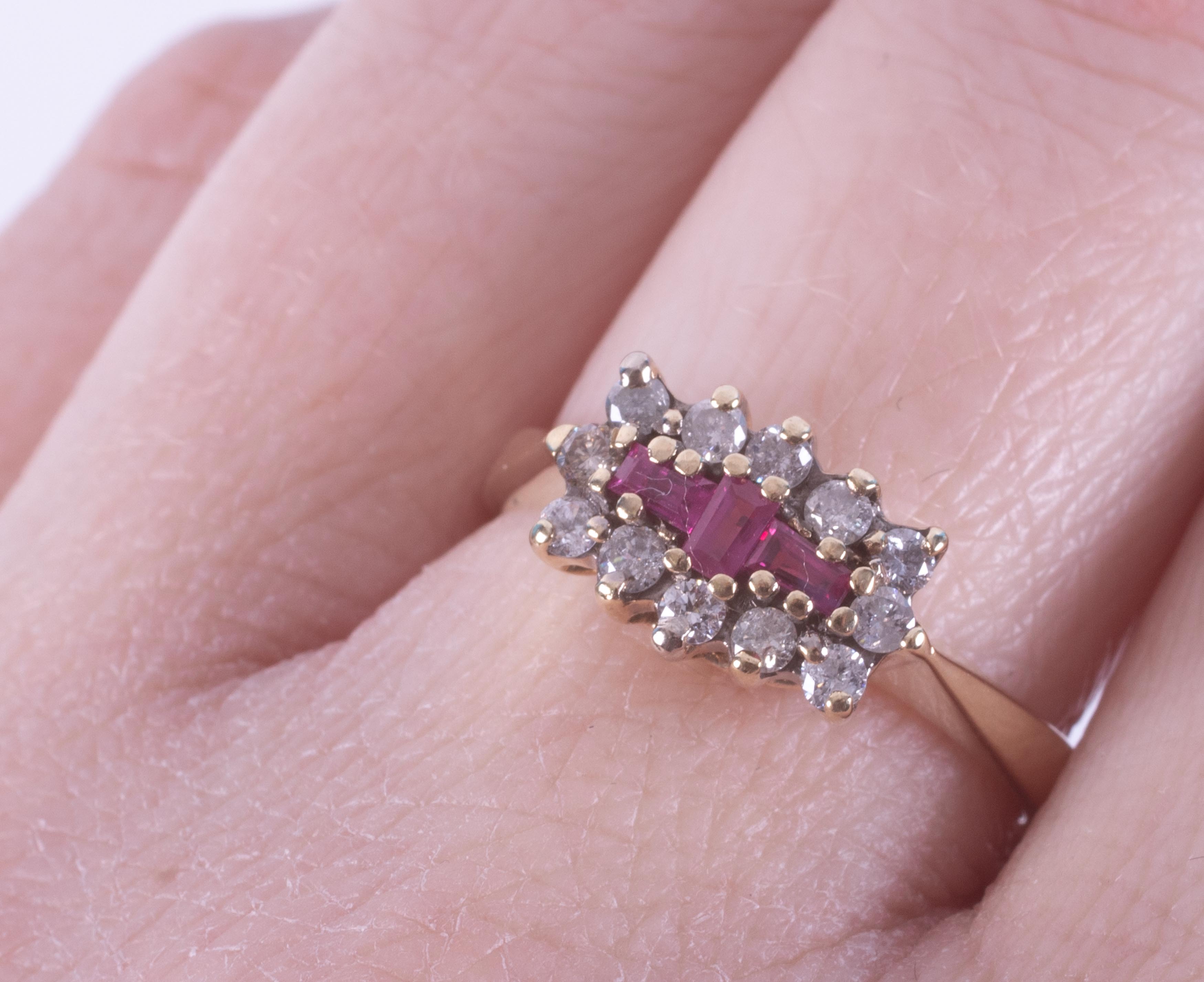 A 9ct yellow gold ring set with three central baguette cut rubies, surrounded by small round - Image 2 of 2