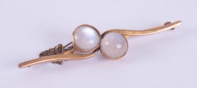 A 9ct yellow gold brooch set with two round cabochon cut moonstones, the moonstones are approx.. 9.