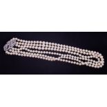 A three row cultured pearl necklace set to an ornate bow design white gold diamond set clasp, the