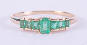 A 9ct yellow gold ring set with seven baguette cut Colombian emeralds, total weight 0.68 carats, 1.
