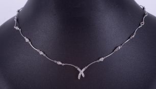 A 14ct white gold articulated necklace with a cross design at the centre set with small round