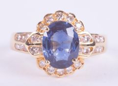 An unusual 18ct yellow gold cluster style ring with a central claw set oval cut sapphire, approx.