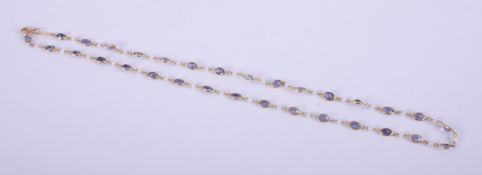 An 18ct yellow gold necklace set with thirty-one oval cut tanzanite's, total weight approx. 13.60