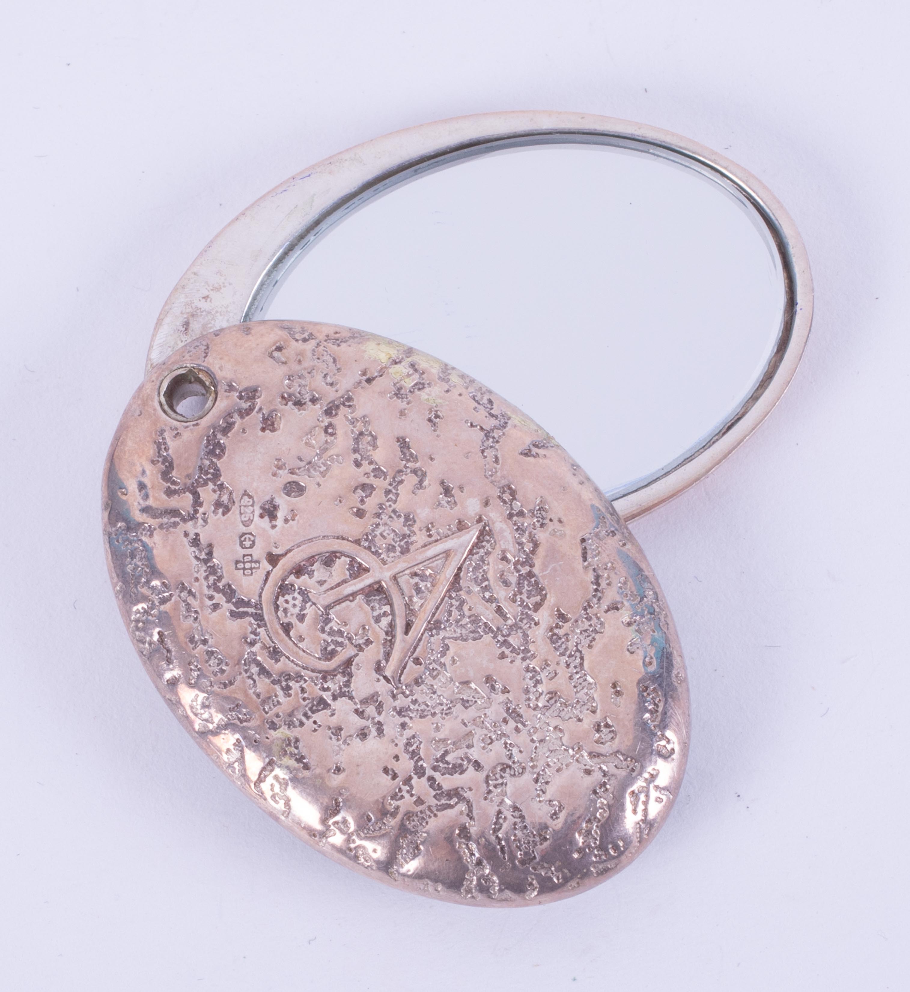An oval silver Asprey Garrard compact mirror, stamped 2000, AG and 925, approx. 4,5cm x 3cm, 33.