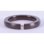 A titanium band with a tension set 0.03 carat round brilliant cut diamond, 3mm x 2.6mm, 1.77gm, size