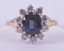 An 18ct yellow & white gold cluster ring set with a central oval cut sapphire, approx. 1.03