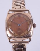 A 9ct yellow gold vintage manual wind gent's wristwatch with a cushion shaped face on a stainless
