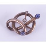 An unusual knotted design brooch (metal not hallmarked or tested) set with two cabochon